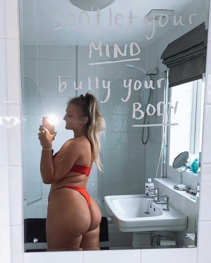 Sophie wearing a red bikini on the beach, posing confidently in front and back view