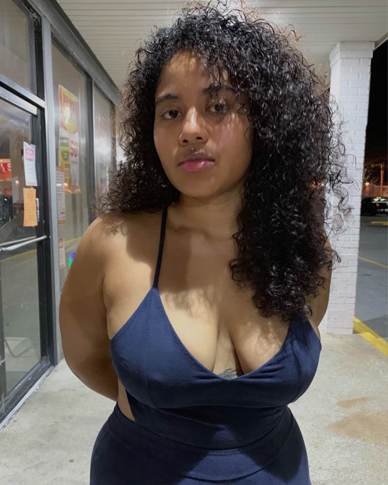 Black girl in a dress, showcasing her natural curves and expressing body positivity.