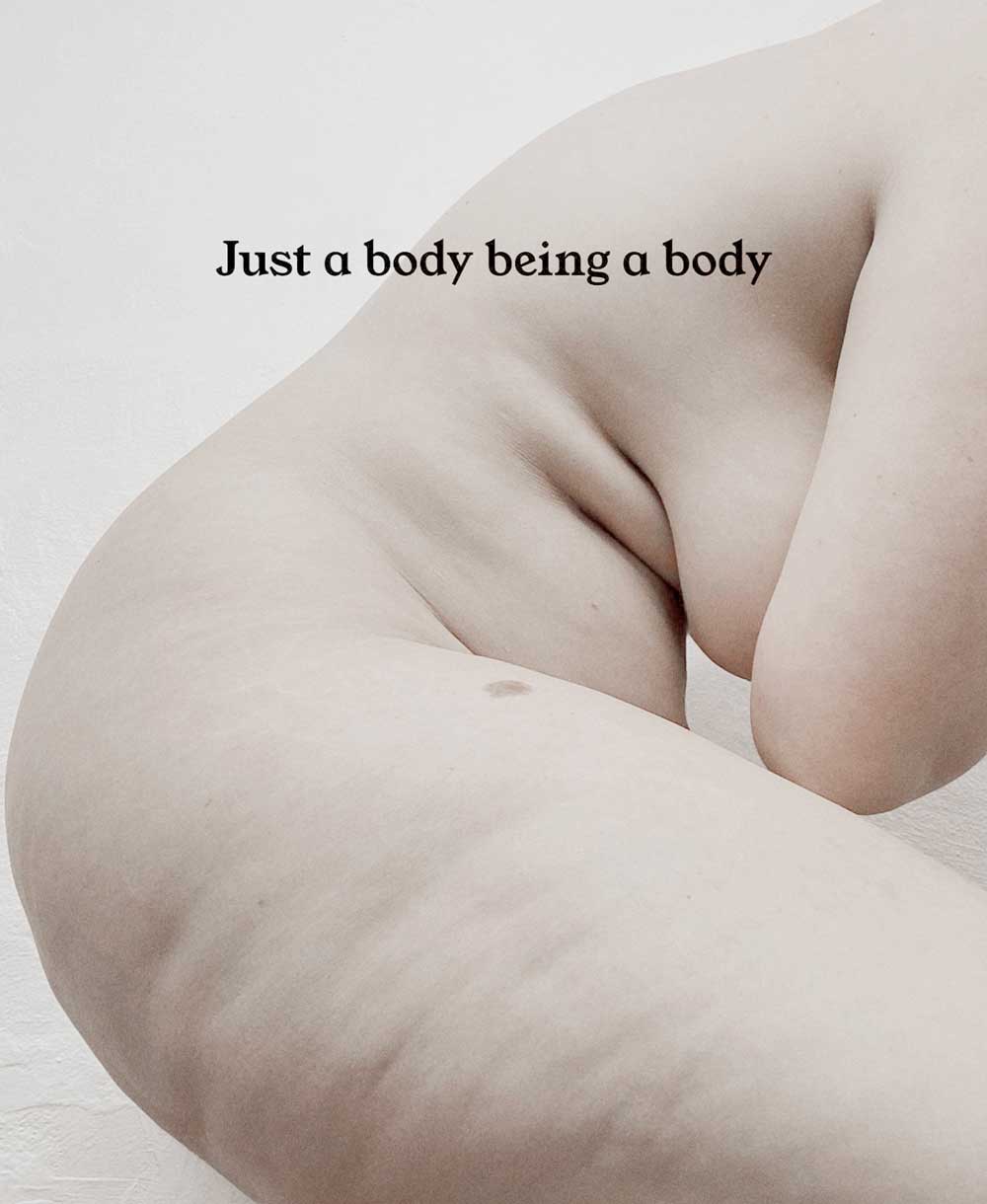 Artistic nude image of a plus size woman embracing her body with thick thighs, tummy, and natural breasts