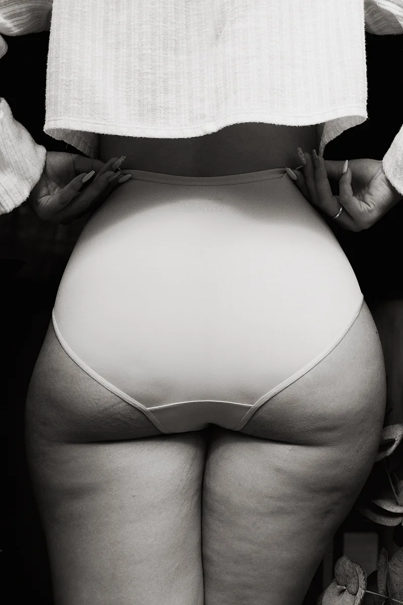 Curvy white woman’s butt with cellulite and stretch marks, natural body, no makeup.
