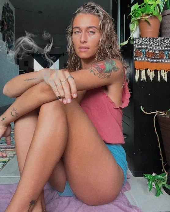 Bailey Rushlow sitting in shorts, capturing her toned legs, confident posture, and captivating gaze