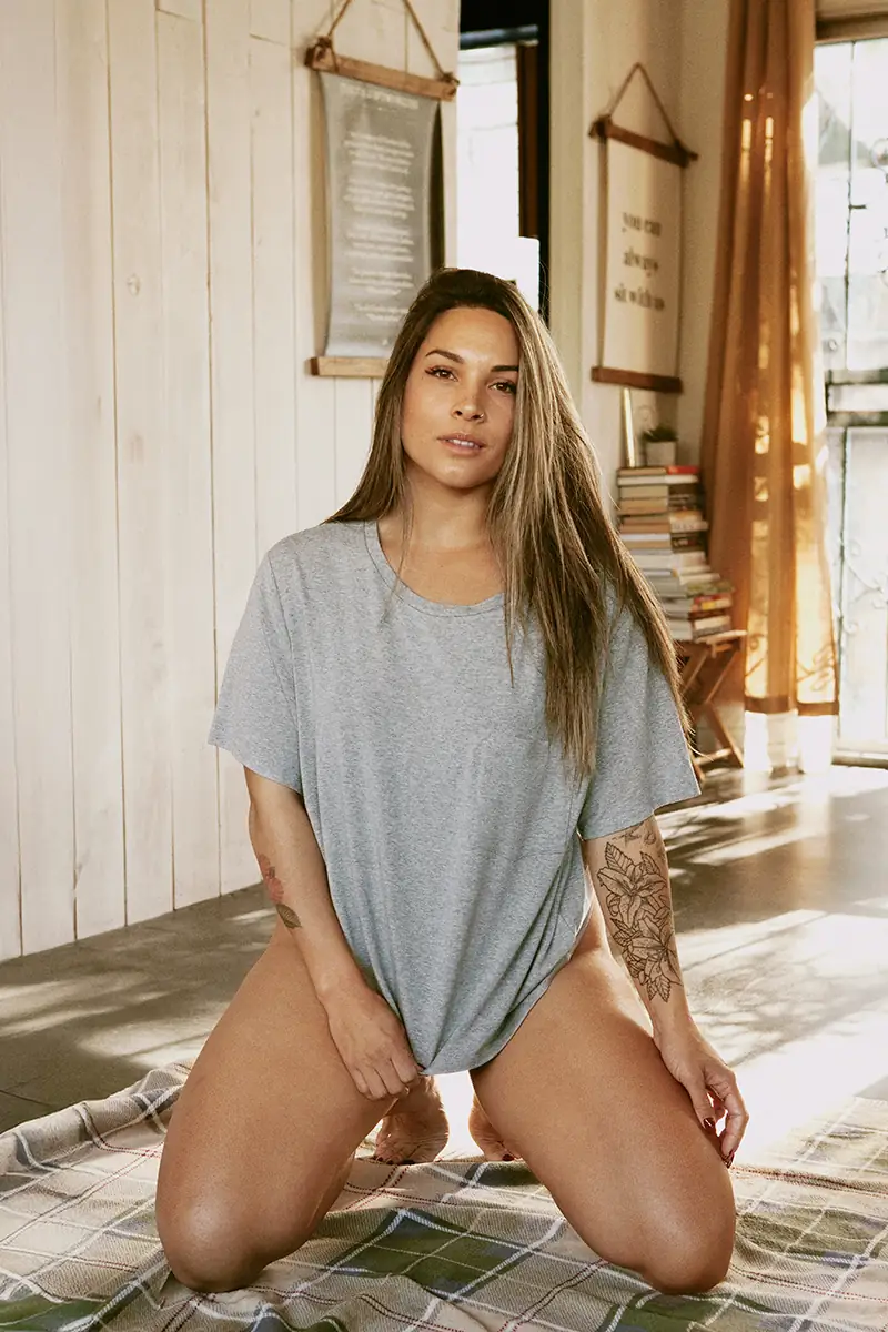Color portrait of a woman with no makeup wearing a long tee, embracing her natural beauty and relaxed style.