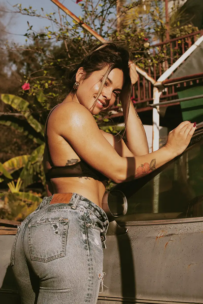 Color photo of a woman in jeans and a sweater, no makeup, embracing her natural beauty and curves while enjoying fitness and movement, highlighting her butt.
