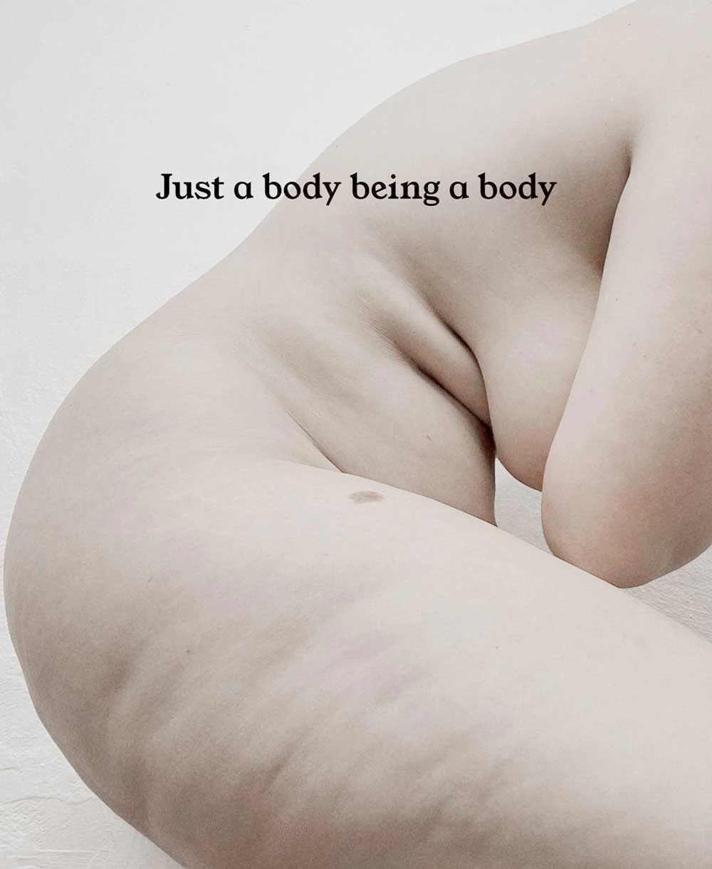 Artistic nude image of a plus size woman embracing her body with thick thighs, tummy, and natural breasts