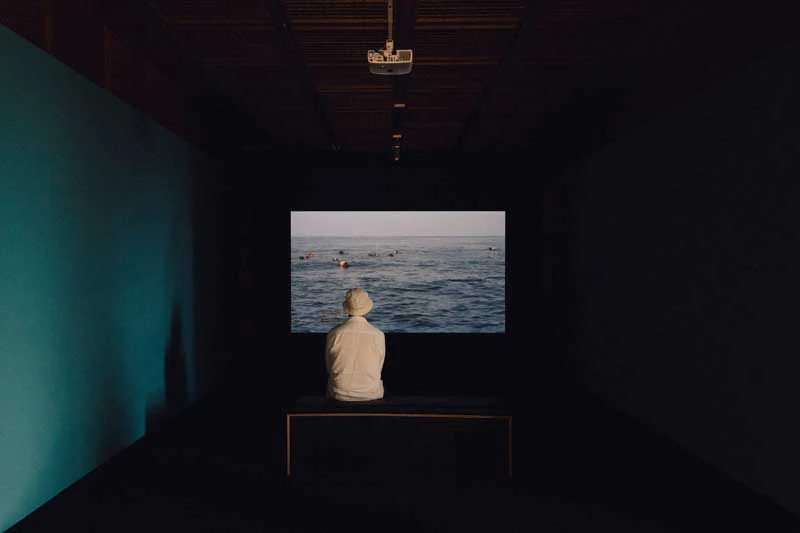 Man in quiet museum space watching video art exhibition on television learning about self discovery 