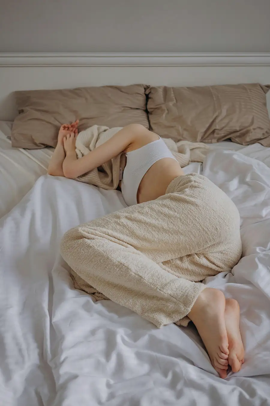 Woman lying in bed in the morning, showing fatigue and low energy.