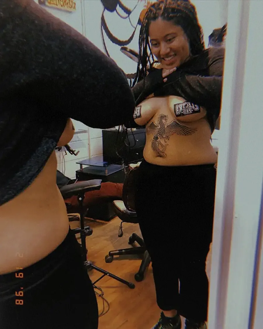 Black girl lifting her shirt to show her body, celebrating body confidence and self-acceptance.