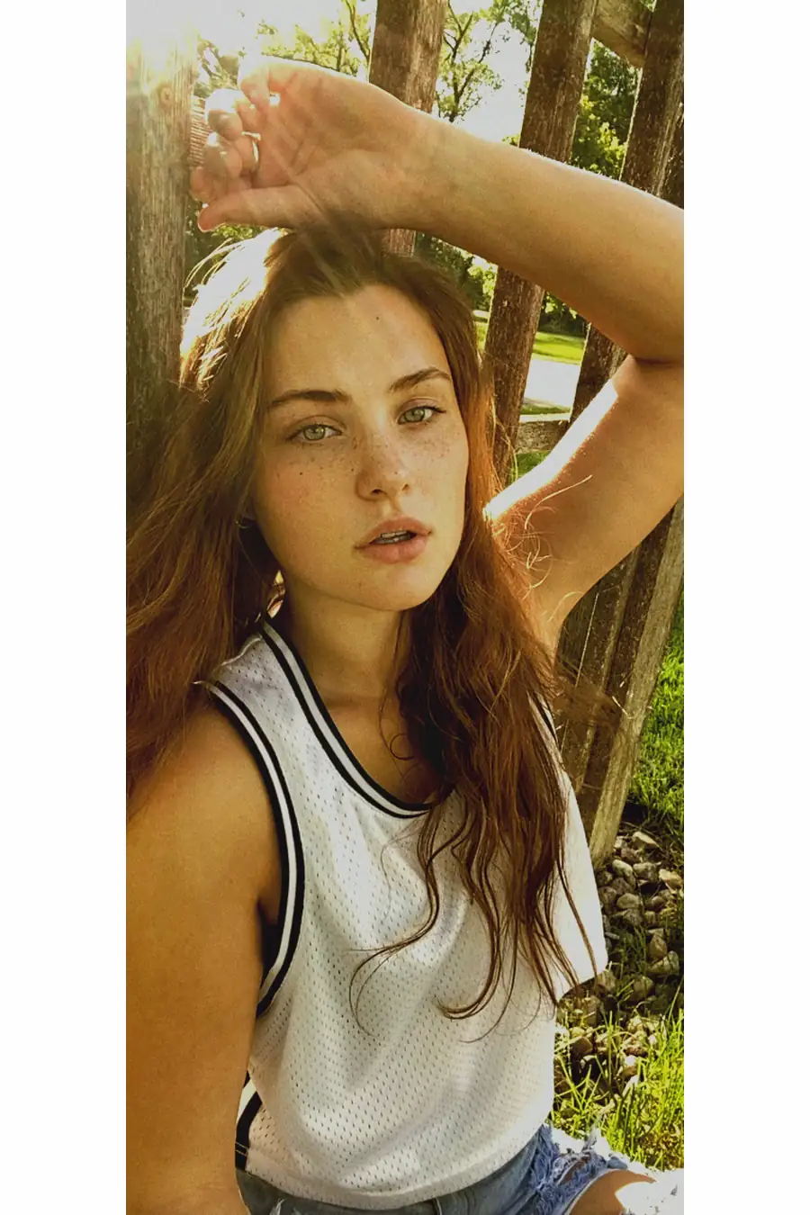 FaceTime photoshoot with Bare Model Gibson in her yard, natural light, freckles visible, unfiltered portrait.