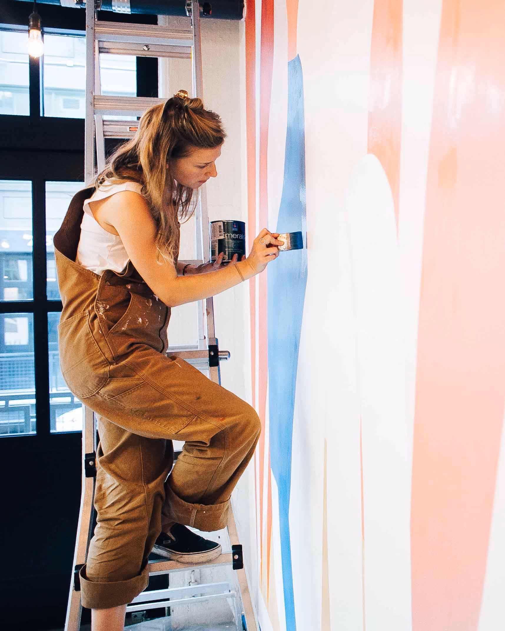 Photograph of Viscaya Wagner painting a mural.