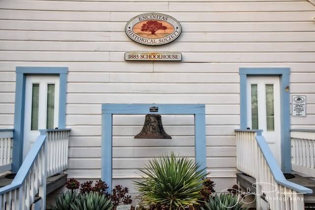 White building with blue trim and a plaque on the front.