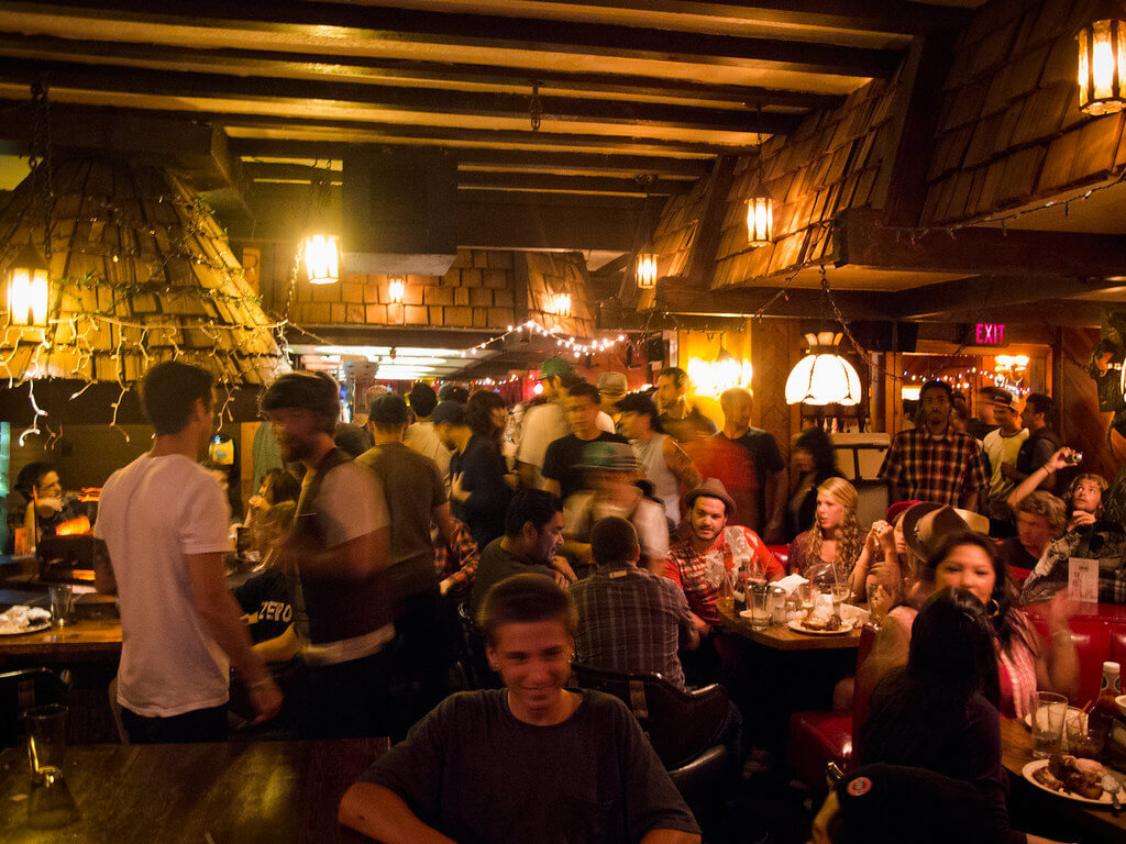 Several dozen people inside Cap'n Keno's bar, drinking, eating, and talking.
