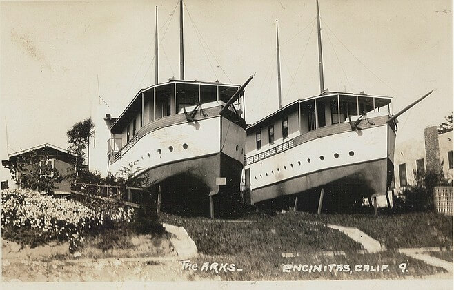 Black and white photo of two boathouses, viewed from the street