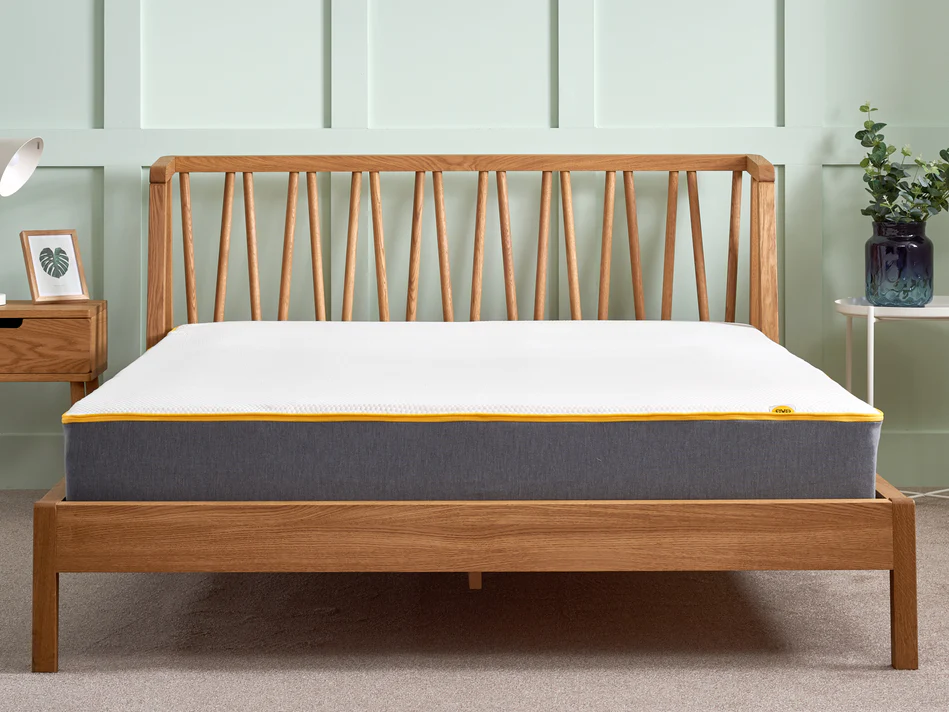The Eve Original Hyrbid mattress in a bedroom showroom setting on a wooden bed frame