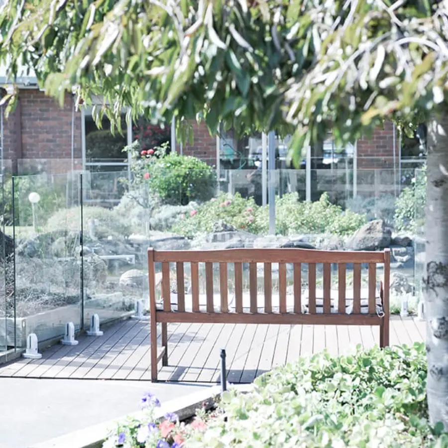 Shaded garden bench at Greenwood Manor, a retirement village in Clayton South, featuring inviting outdoor spaces.