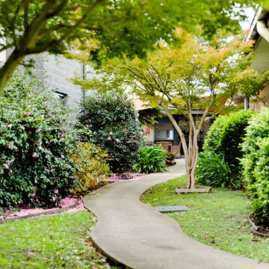 Peaceful garden walkway at an aged care facility near Hampton Park offering residents calm, outdoor living spaces.