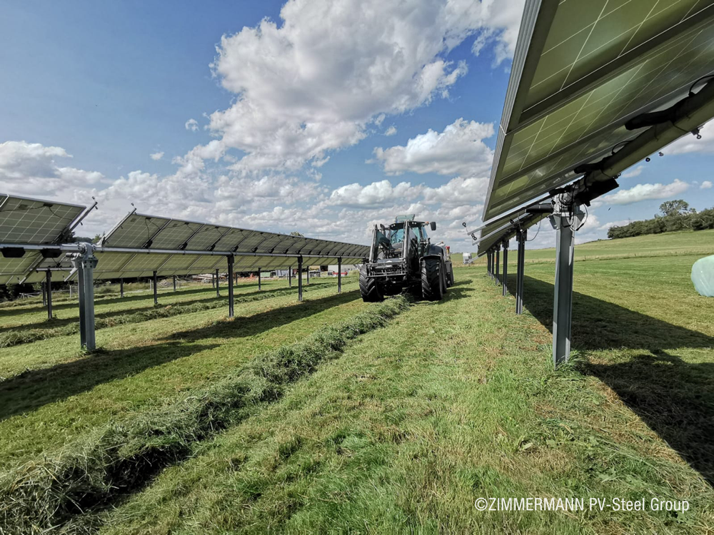Ein Traktor zwischen Solarmodulen