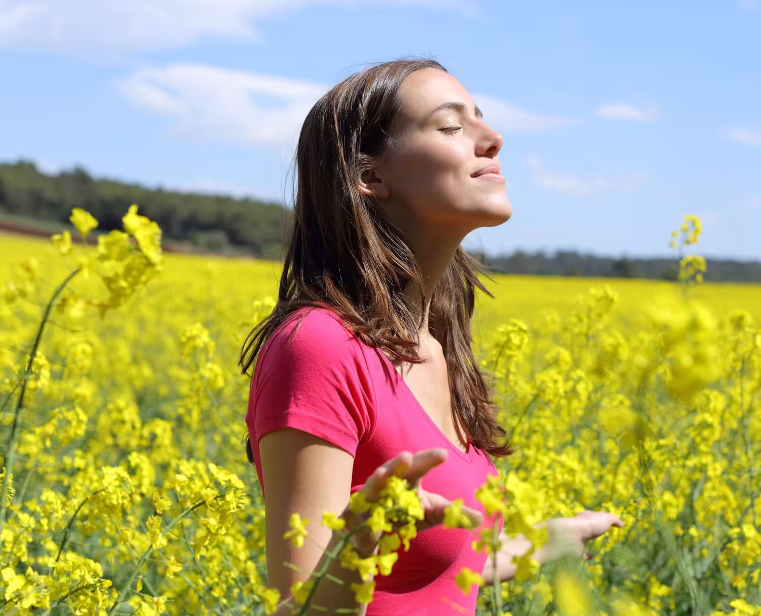 Woman breathing freely outdoors in a flower field after allergy relief