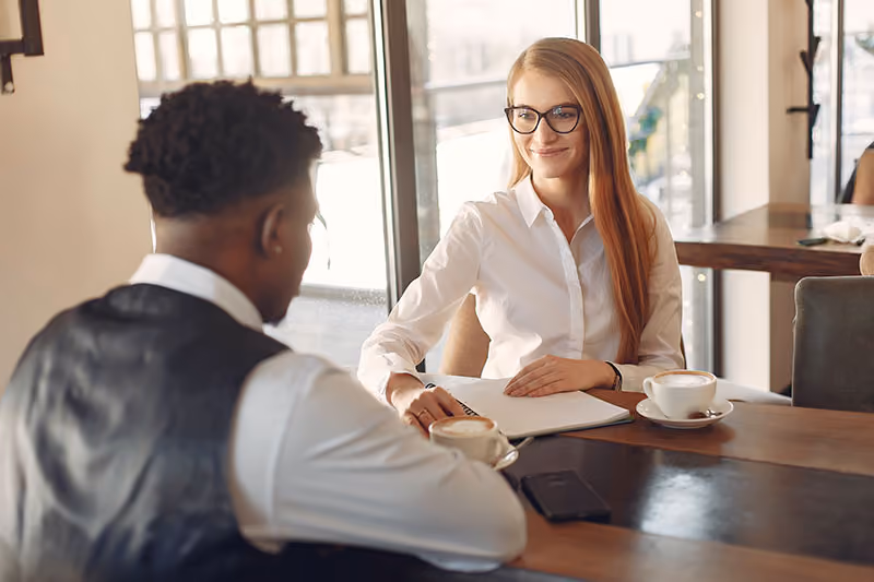 Interview with an HR professional smiling at a promising job candidate.
