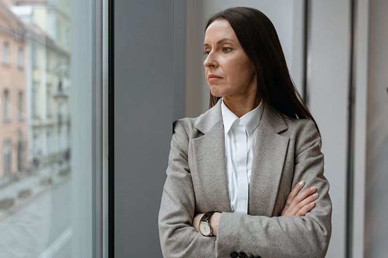 Unhappy and disengaged worker looking out an office window