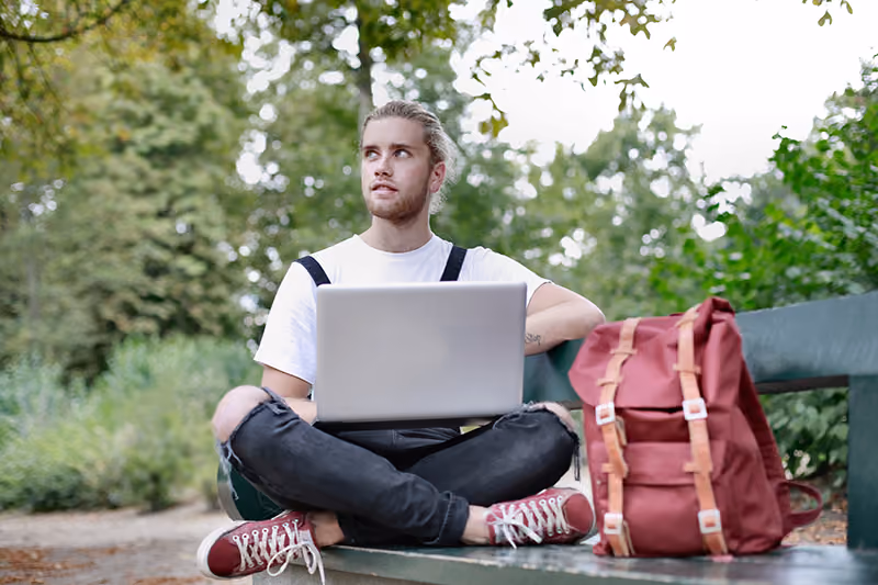 Digital nomad working remotely from a bench while traveling