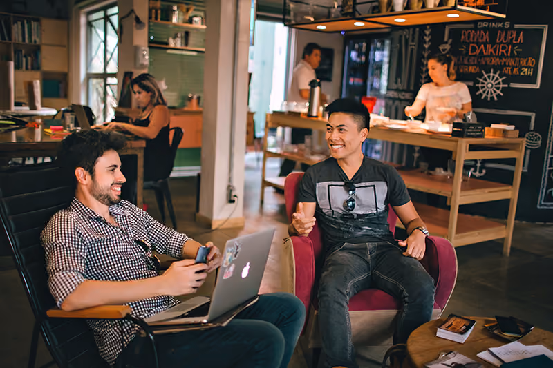 Two remote workers meeting in a cafe to collaborate.
