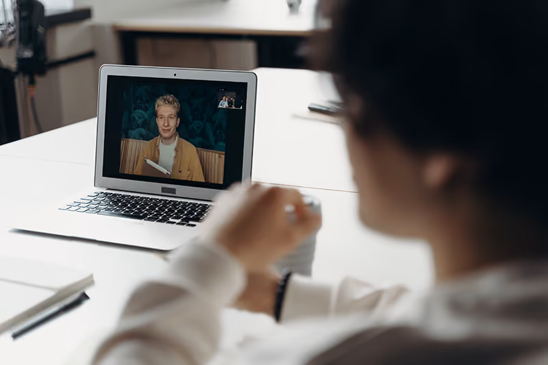 A hybrid employee dialing in remotely to attend an in-office meeting.
