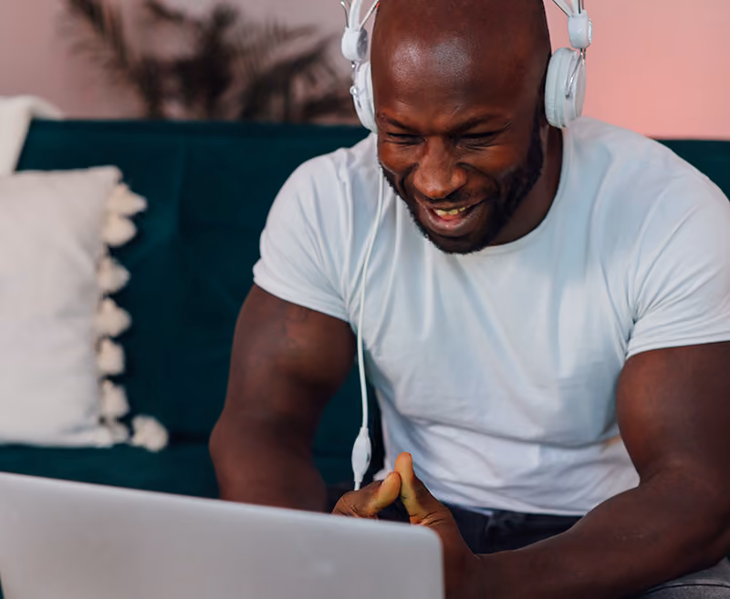 A remote employee smiling at virtual recognition messages on his computer