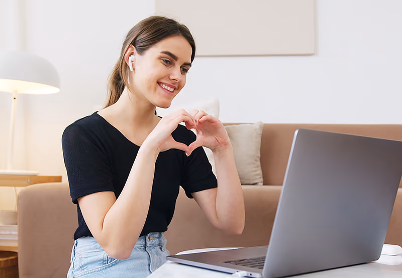 An employee working from home expressing gratitude to her peers in a virtual company meeting.