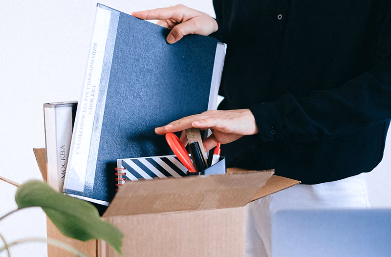 A worker packs up her desk after getting laid off