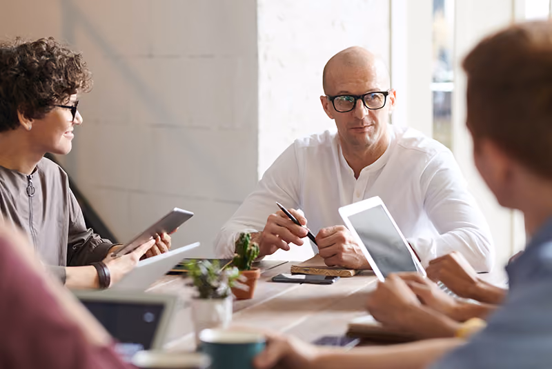 A fractional executive sits in on a meeting with employees.