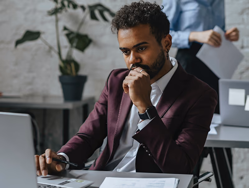 An employee at this laptop but unable to focus on work due to financial concerns.