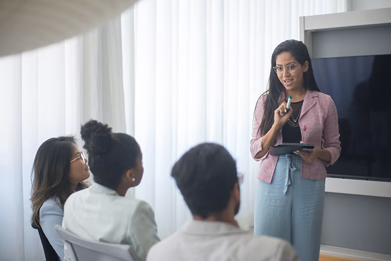 An HR leader presenting workplace training to educate employees on financial wellness.