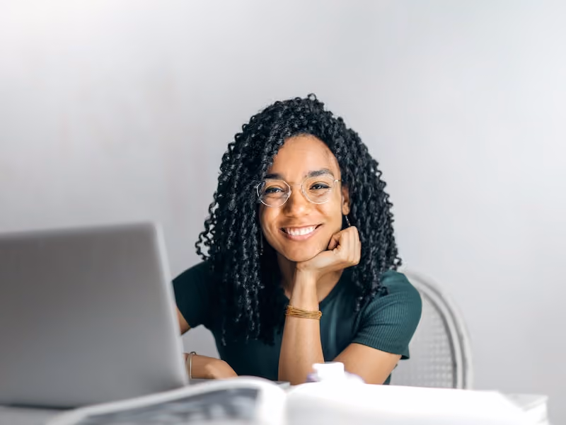 A happy employee using a self-service portal via their employer’s HRIS software.