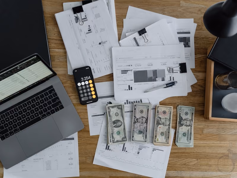 Prepared financial incentive compensation for employees, counted out in bank notes placed on a desk next to documents and a laptop.