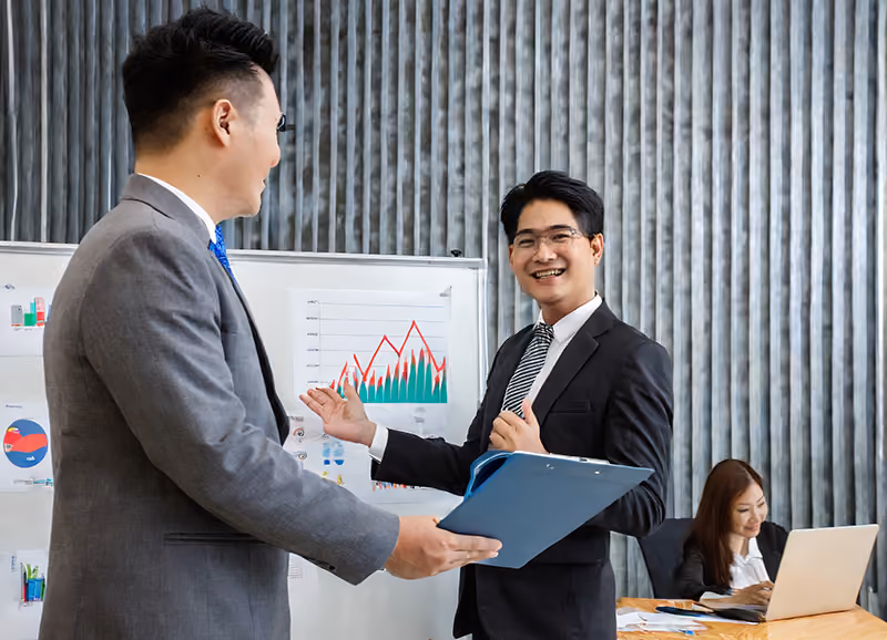 An employee receives a glowing performance review and a merit increase after a presentation where he shows graphs of positive organizational results.