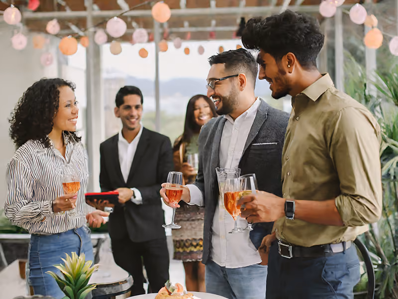 Co-workers having drinks with their new colleagues at a welcome event.