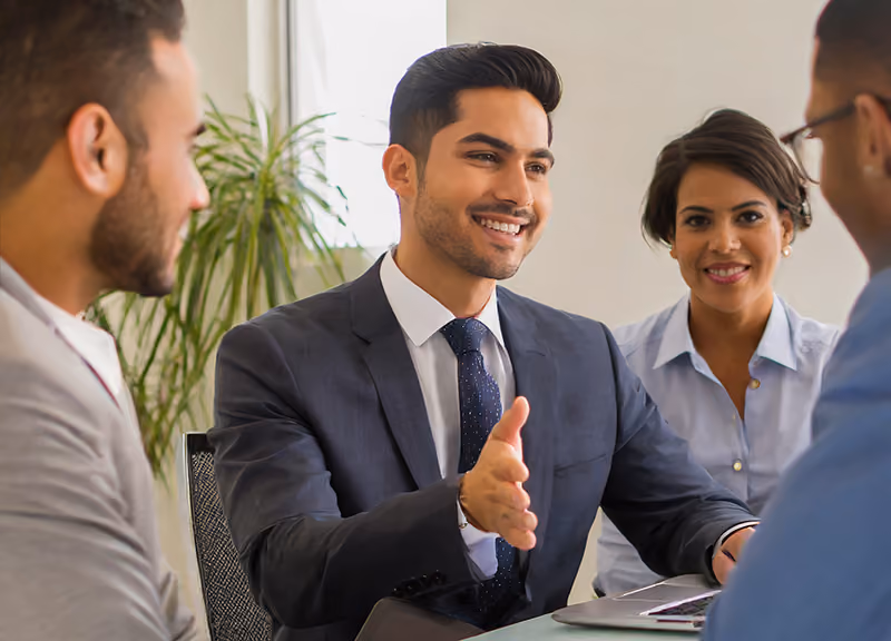 A manager and HR professionals having a check-in meeting with a new hire after their first 90 days at the company.