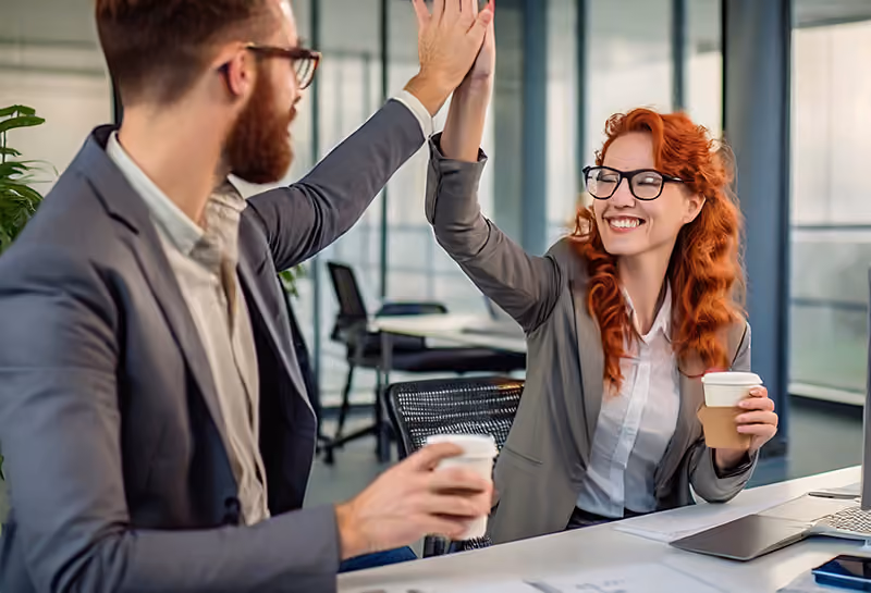A manager recognizing an employee’s achievements with a high-five and a coffee.