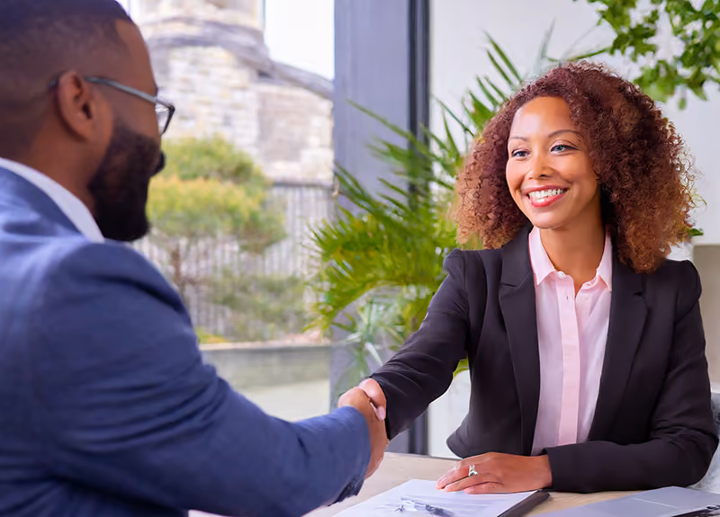 A recruiter shaking hands with a candidate in a job interview.