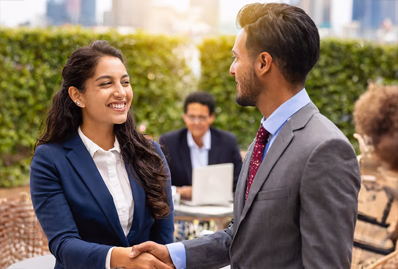 Two PeopleOps professionals building connections at a networking event.
