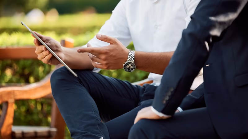 an employee showing a colleague information on a tablet device.