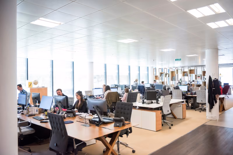 Workers at their desks in an open-plan office.