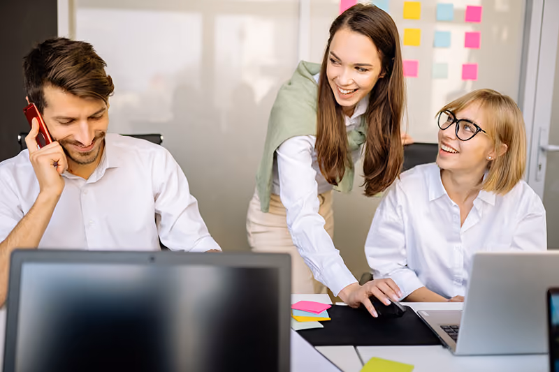 Employees working together in an office using a team collaboration tool to strategize.
