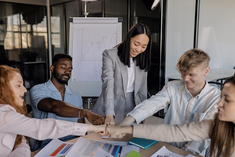 A manager thanking her team for their creative input with a group fistbump as an example of positive feedback for recognizing creativity