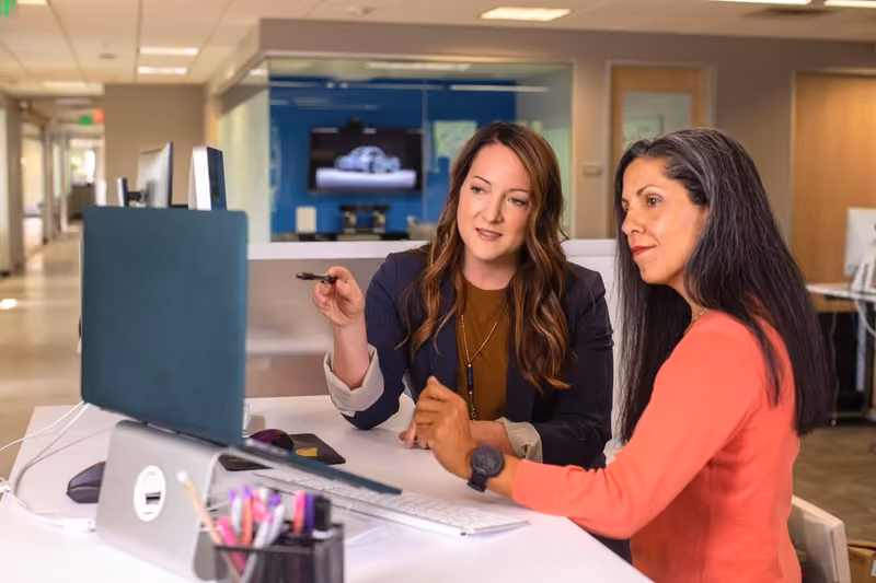 Two-women-brainstorming-award-categories-for-employees-with-good-behavior-and-values