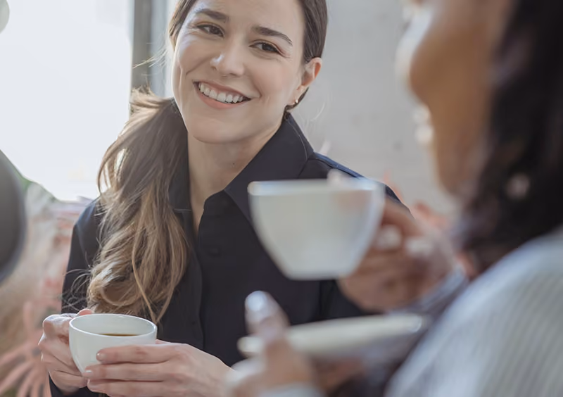 Two-colleagues-having-coffee-together-as-they-participate-in-a-coffee-buddy-employee-recognition-program