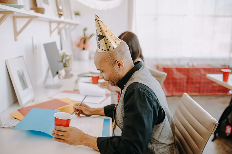An-employee-wearing-a-party-hat-on-his-work-anniversary-employee recognition-program-idea