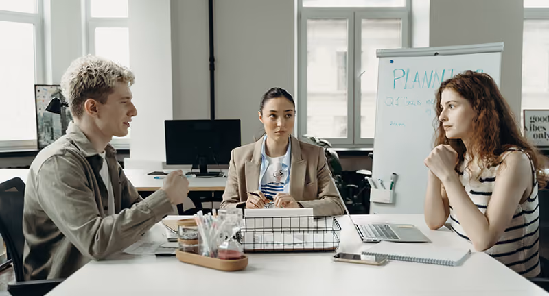 Three-HR-colleagues-brainstorming-new-employee-recognition-program-examples-and–ideas