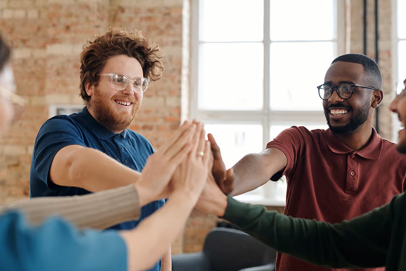 Co-workers high-fiving their newest colleagues.