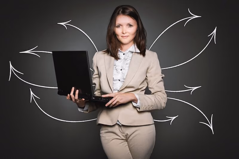 A woman holding a laptop with drawn arrows pointing various directions